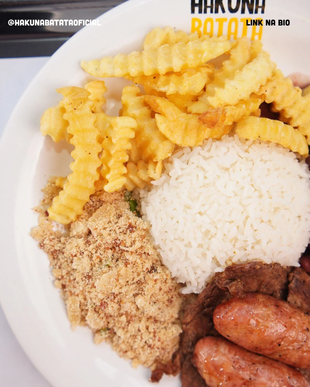 Prato de almoço executivo completo com arroz, feijão, farofa, bife grelhado, linguiça e batata frita ondulada